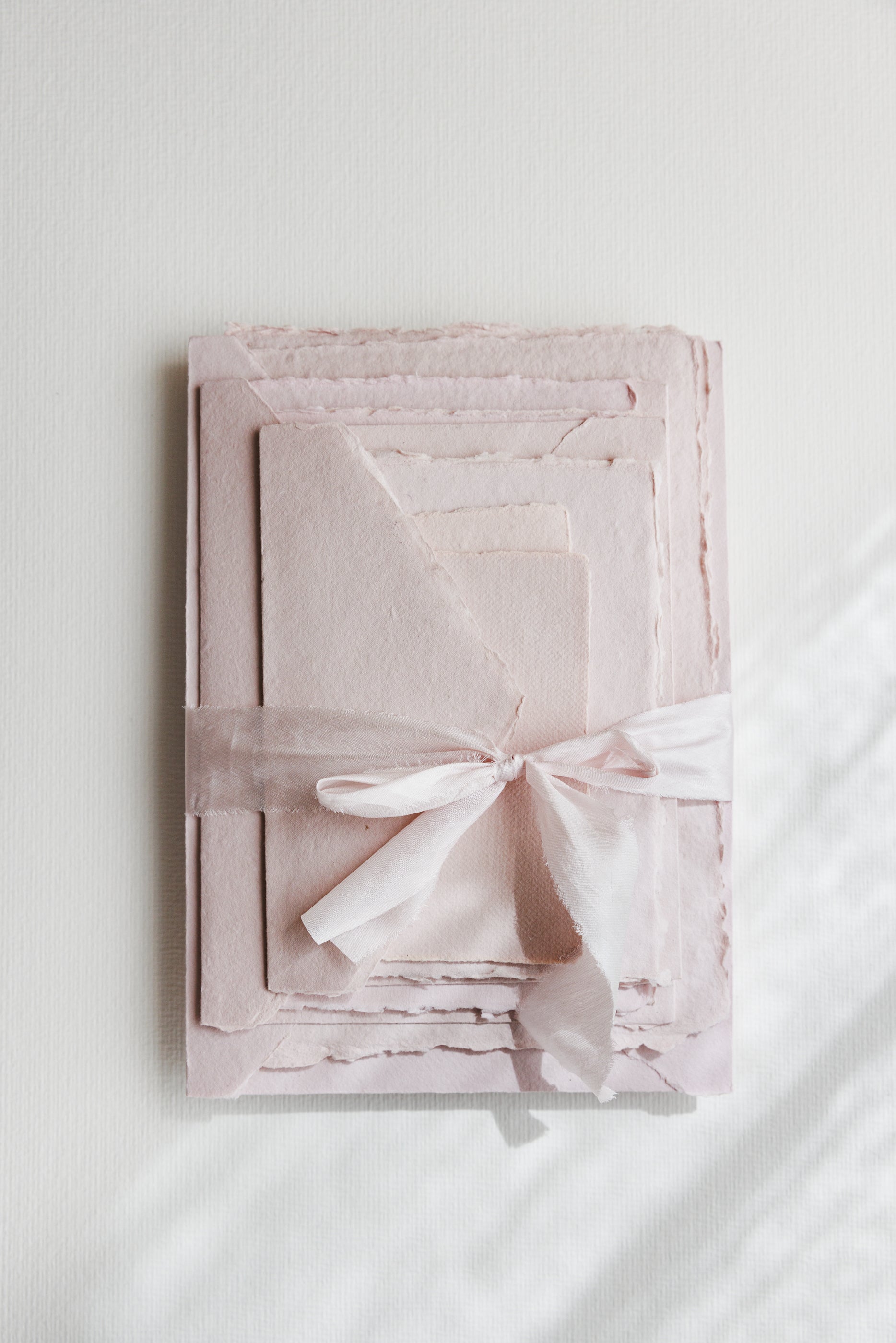 Blush paper and matching envelopes with blush silk ribbon