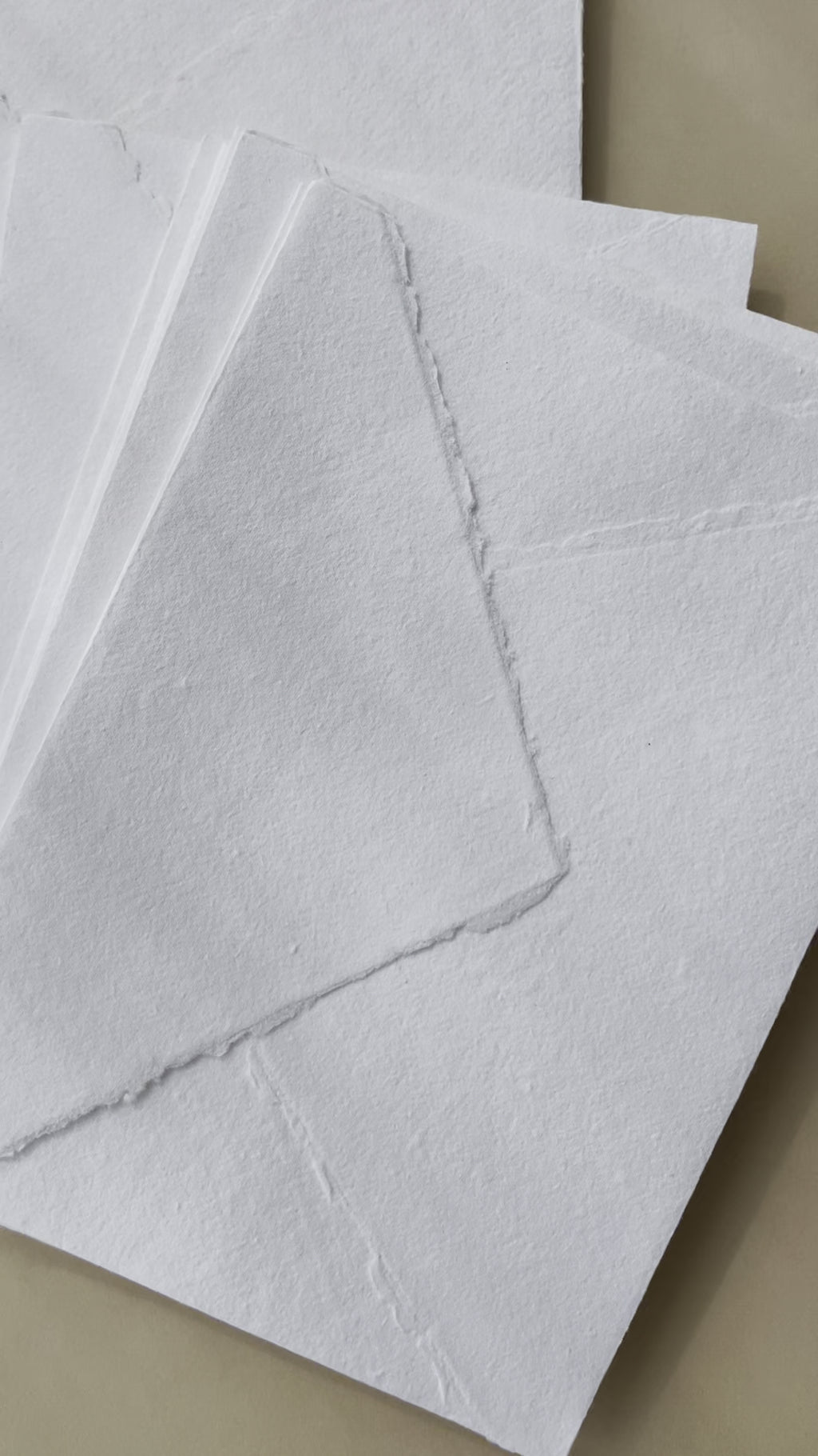 White cotton rag envelopes with a deckle edge finish.